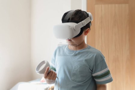 Kid boy playing with virtual reality goggles or VR headset, Child having fun indoors activity with family at home,Concept Video Gaming with learning modern technology glasses for School Children