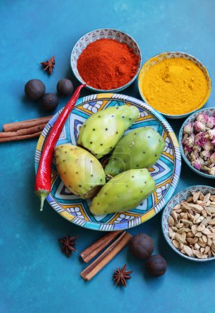 Photo for Still life with colorful fruit and spices on a table. Top view photo of grapefruit, paprika, turmeric powder, chili pepper, ginger, roses, lavender, anise and cinnamon. Blue background. - Royalty Free Image