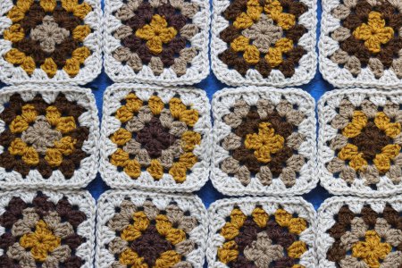 Téléchargez les photos : Photo rapprochée de motifs carrés crochetés en laine douce. Couverture de style rétro dans la fabrication. Crochet texture motif. - en image libre de droit