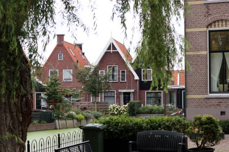 Photo for Classic Dutch houses on a street. Cute buildings with red tiles roof. Architecture of the Netherlands. - Royalty Free Image