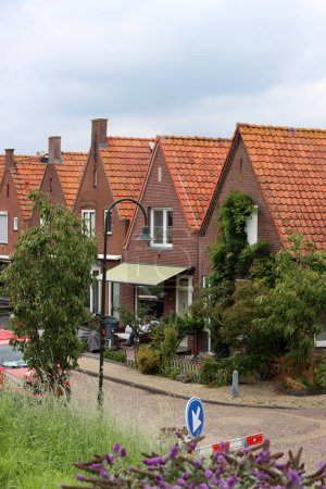 Photo for Classic Dutch houses on a street. Cute buildings with red tiles roof. Architecture of the Netherlands. - Royalty Free Image