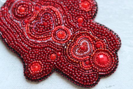 Photo for Wall hanging decoration made of red beads on a light background with copy space. Hamsa hand symbol. New Year card. - Royalty Free Image