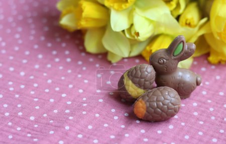 Milk chocolate bunny and eggs on a table. Bright and colorful Easter card. 
