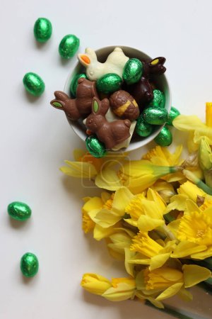 Chocolate candies and daffodils. Springtime holidays concept.
