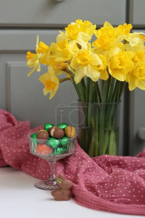 Téléchargez les photos : Bouquet de jonquilles dorées dans un vase en verre sur fond de bois vert avec espace pour le texte. - en image libre de droit
