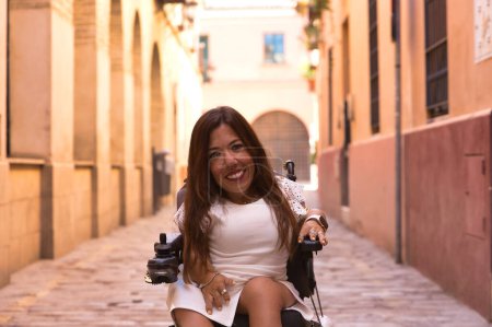 Frau mit Behinderung, eingeschränkter Mobilität und kleiner Statur posiert fröhlich und kokett im Elektro-Rollstuhl auf einer Stadtstraße. Konzept Behinderung, Behinderung, Invalidität, besondere Bedürfnisse.