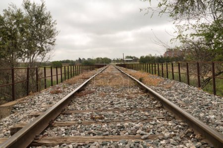 Téléchargez les photos : Détail des rails des voies d'un train qui sont perdus dans l'infini entouré de rochers. Concepts trains, voies ferrées, transports, routes. - en image libre de droit