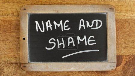 die Worte "Name und Schande" auf einer Schiefertafel geschrieben