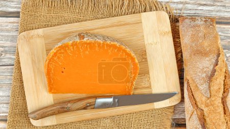 Scheibe französischer Käse: extra alte Mimolette, Nahaufnahme, auf einem Schneidebrett