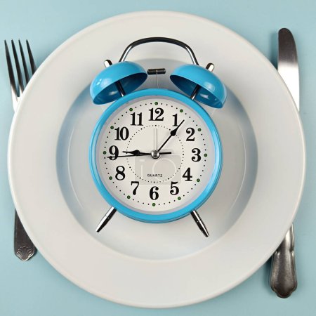 alarm clock on a plate with blue background