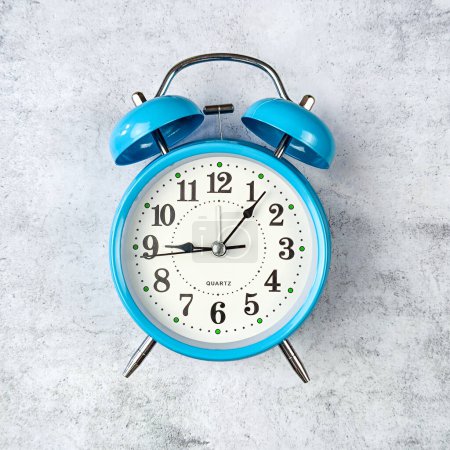 an alarm clock placed on a gray background