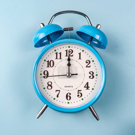 un despertador colocado sobre un fondo azul