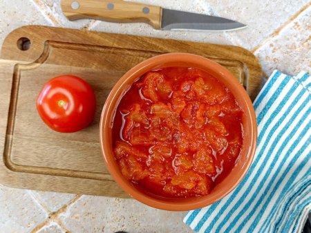 bowl of crushed tomatoes, close-up, on a cutting board