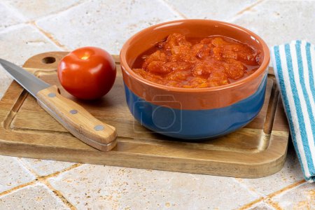 bowl of crushed tomatoes, close-up, on a cutting board