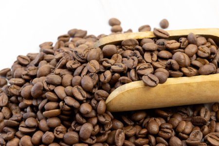 cuillère en bois remplie de grains de café, gros plan