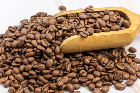 cuillère en bois remplie de grains de café, gros plan