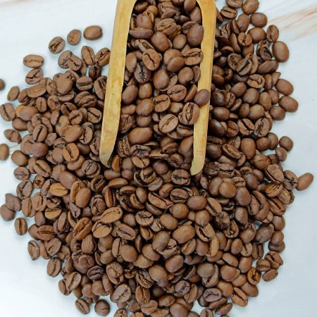 cuchara de madera llena de granos de café, primer plano