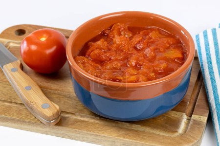 bol de tomates concassées, gros plan, sur une planche à découper