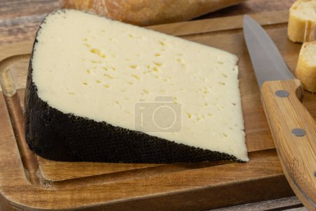 El trozo del queso: el tomme noire de los Pirineos, el primer plano, a la mesa