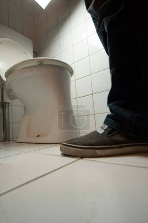 Foto de Urination of a person on a toilet in a restroom - Imagen libre de derechos