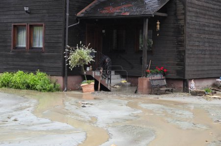 Téléchargez les photos : Bâtiment dans une zone inondée après de fortes pluies, eau boueuse - en image libre de droit