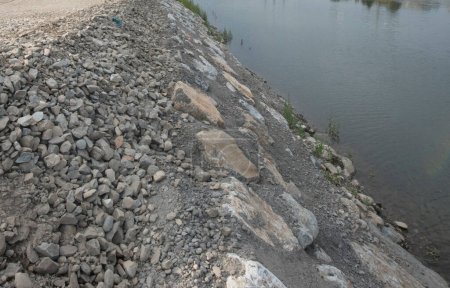 Foto de Apuntalamiento de piedra en la orilla del río en la regulación del río y la ingeniería hidráulica - Imagen libre de derechos