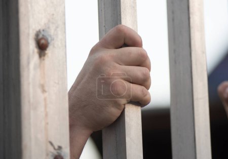 Téléchargez les photos : Prisonnier regardant par la fenêtre d'une cellule de prison - en image libre de droit