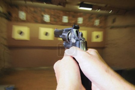Photo for Target shooter at a shooting range, indoor sports with weapon - Royalty Free Image