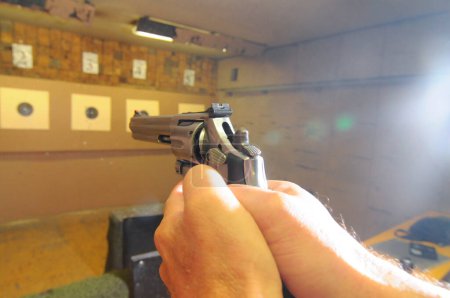 target shooter at a shooting range, indoor sports with weapon