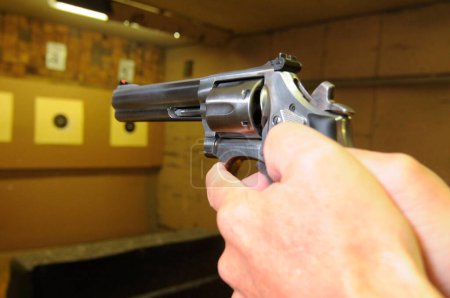 target shooter at a shooting range, indoor sports with weapon