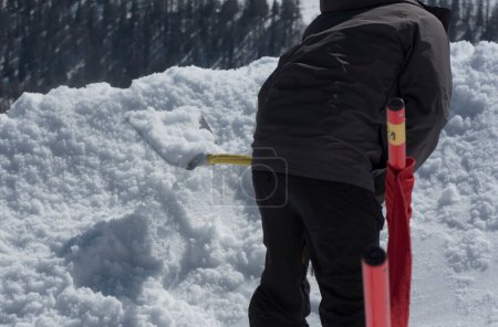 persona en la eliminación de la nieve con una pala de nieve en invierno