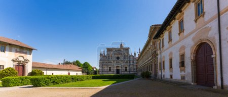 Certosa di Pavia monastery, historical monumental complex that includes a monastery and a sanctuary. green court and a church.The Ducale Palace on the right,Pavia,Italy.