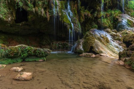 Téléchargez les photos : La cascade de Baume-les-Messieurs est une destination touristique en été. Jura, France. - en image libre de droit
