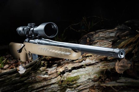 Téléchargez les photos : Fusil de chasse Bolt action centerfire dans une forêt sombre avec une portée - en image libre de droit