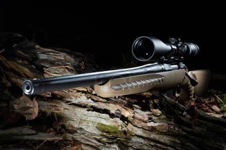 Téléchargez les photos : Optique haute puissance sur un fusil de chasse à action de boulon dans une forêt sombre - en image libre de droit
