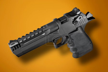 Foto de Vista trimestral de una pistola semiautomática sobre un fondo naranja - Imagen libre de derechos