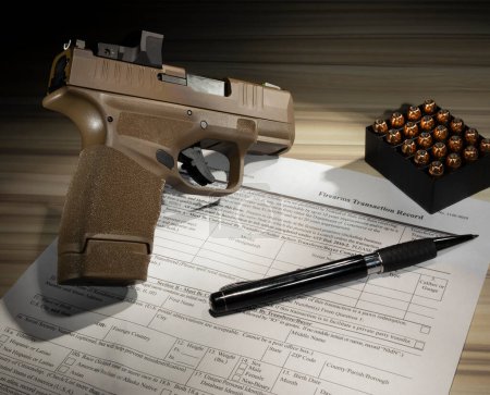 Téléchargez les photos : Pistolet et cartouches avec formulaire 4473 du domaine public requis pour l'achat d'une arme à feu - en image libre de droit
