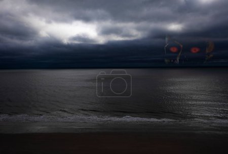 Photo for Skull in a storm waiting for victims in a storm approaching the shore - Royalty Free Image