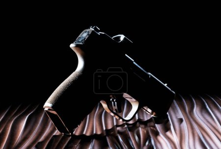 Photo for Dark semi-automatic handgun chambered in 9 mm with no discernible features much like a ghost gun - Royalty Free Image