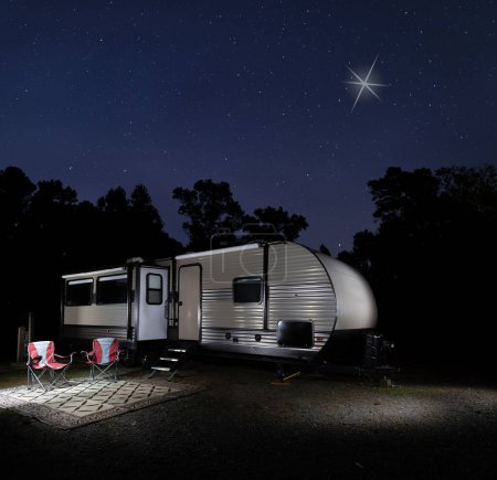 Heiligabend mit dem Weihnachtsstern über einem von Bäumen und Sternen umgebenen Campingplatz mit Wohnmobil