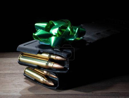 Photo for Green bow on top of two loaded high capacity AR-15 magazines on a table as a gift for a gun owner. - Royalty Free Image