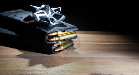 Zwei Magazinen für Sturmgewehre mit hoher Kapazität und voller Ladung unter einem silbernen Bogen als Geschenk für einen Waffenbesitzer am Vatertag, Geburtstag oder Weihnachten.