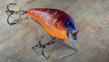 Plastic fishing lure on a rock with copy space on the right