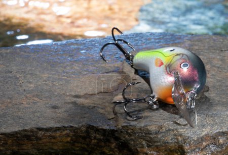Bright water behind an artificial fishing bait on a rock