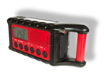 Weather radio that runs on batteries or hand crank or solar with a flashligght for emergencies with a shadow behind.