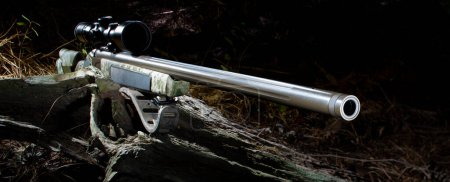 Ein 50-Kaliber-Gewehr mit Vorderladergewehr und Zielfernrohr für die Jagdsaison im dunklen Wald unter die Lupe nehmen