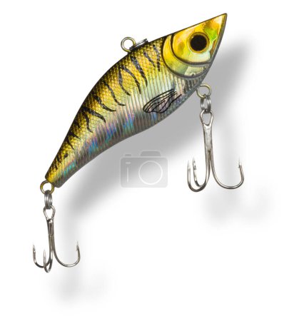 Artificial fishing lure with gold and yellow color and two treble hooks with drop shadow under rising toward the surface.