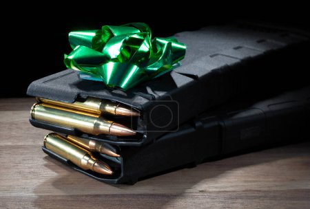 Photo for High capacity assault rifle magazines loaded with bullets and with a green bow on top to make the perfect gift for a firearm owner. - Royalty Free Image