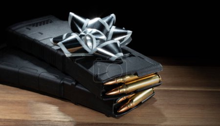 Silver and white bow on polymer assault rifle magazines that are loaded with ammunition. 
