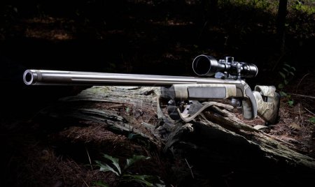 Rifle cargador de boquillas en línea con óptica en un maldito bosque